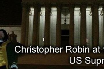 Person in costume at night in front of the illuminated US Supreme Court building.
