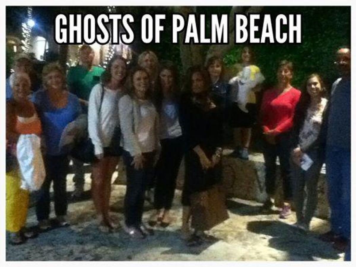 Group of people posing outdoors at night under 'Ghosts of Palm Beach' text.