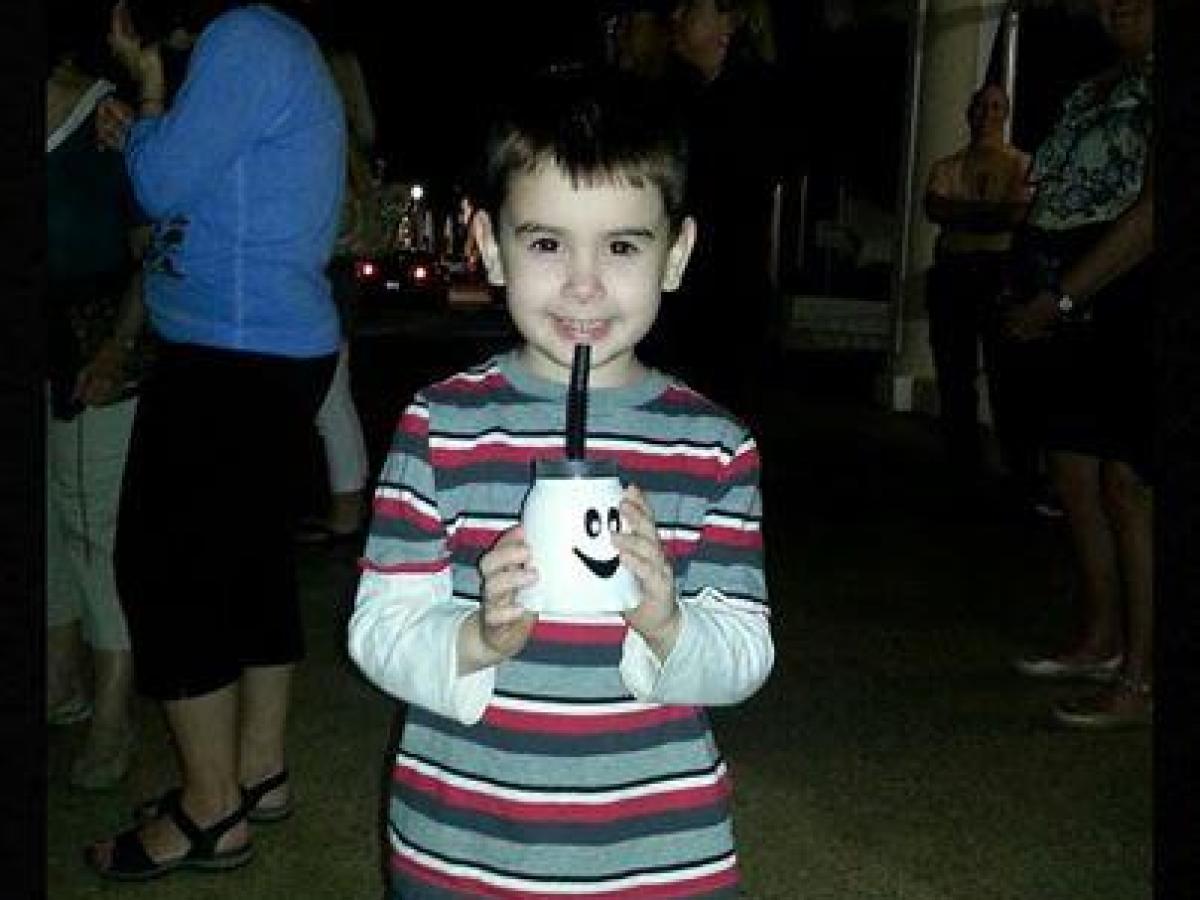 Child holding a cup with a smile, wearing a striped shirt. Text: 'Ghosts of Palm Beach Trivia Challenge Winner!'